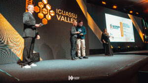 Na imagem está o vice-presidente do Biopark Educação recebendo o troféu do prêmio em cima de um palco.